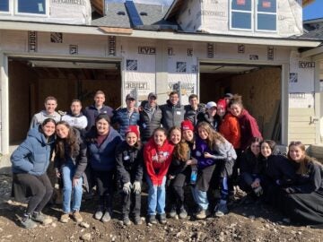 Student volunteers from Columbia / Barnard Hillel (NY) pose in front of a Habitat home under construction