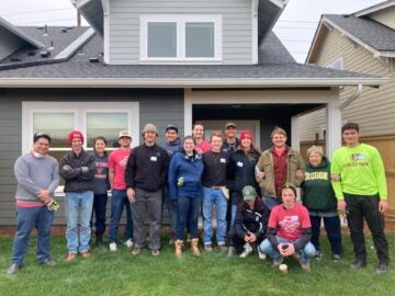 student volunteers from University of Oregon pose at a Habitat home 