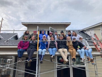 a group photo of Sacred Heart students on scaffolding at a construction site