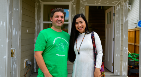 Jerard and Thi, stand in front of their home while it was under construction.